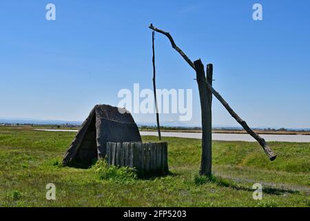 Österreich, traditioneller alter Ziehbrunnen und Jurte aus Stroh am winzigen See, Teil der eurasischen Steppe im Burgenland und Teil der internationalen Union für Kontra Stockfoto