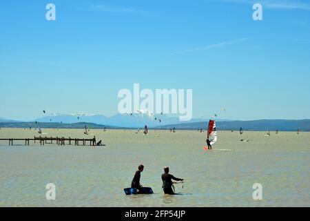 Podersdorf, Österreich - 09. Mai 2021: Unbekannte Menschen, Wassersport mit Kite- und Windsurfern im Seebad am Neusiedlersee, Burgenland Stockfoto