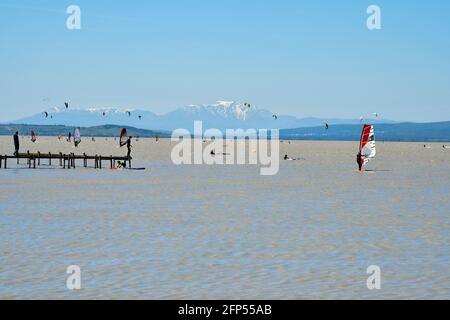 Podersdorf, Österreich - 09. Mai 2021: Unbekannte Menschen, Wassersport mit Kite- und Windsurfern im Seebad am Neusiedlersee, Burgenland Stockfoto