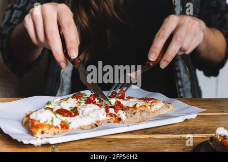 Frau, die im Restaurant Pizza isst Stockfoto