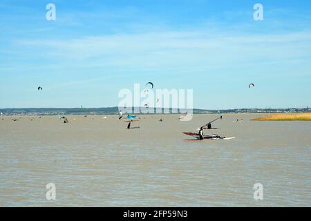 Podersdorf, Österreich - 09. Mai 2021: Unbekannte Menschen, Wassersport mit Kite- und Windsurfern im Seebad am Neusiedlersee, Burgenlan Stockfoto