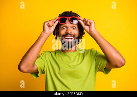 Foto von jungen afro Mann Hände berühren Sonnenglas glücklich positiv Überrascht überrascht überrascht News Verkauf isoliert über gelbe Farbe Hintergrund Stockfoto