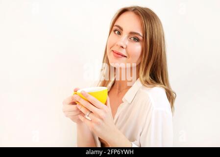 Erwachsene Frau in Robe, die die Augen schließt, während sie eine Tasse davon hat Aromatischer, frisch gebrühter schwarzer Kaffee Stockfoto