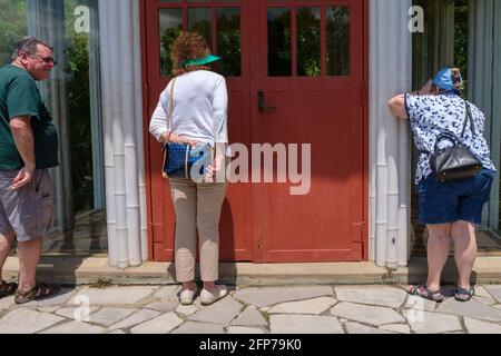 Touristen gucken durch die Fenster zur buddhistischen Tempelattraktion in den Jungle Gardens in Avery Island, Louisiana, USA Stockfoto