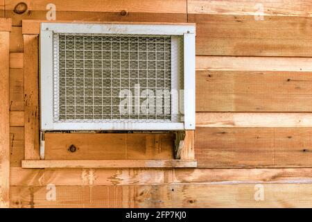 Horizontale Aufnahme einer Fensterklimaanlage in einer Holzwand mit Kopierraum. Stockfoto