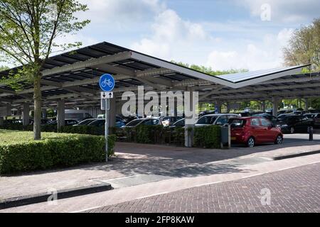 Solarzellen, die auf dem Vordach eines Parkplatzes im Zentrum der niederländischen Stadt Dronten installiert sind. Nachhaltige Energie und Schatten Stockfoto