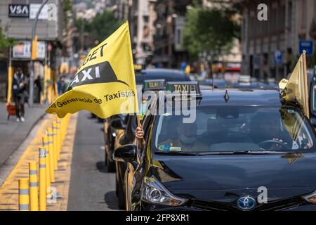 Barcelona, Spanien. Mai 2021. Ein Taxi hat mit einer Flagge gesehen, wie es Vía Laietana verlangsamte.Gewerkschaften und Taxigruppen haben mit einem langsamen marsch von Fahrzeugen durch die Stadt demonstriert. Beim Stadtrat von Barcelona haben sie sich mit Vertretern der Stadtverwaltung getroffen. Taxifahrer wollen eine größere kommunale Kontrolle über die Verwaltung des Uber-Betreibers sowie die Finanzierung einer mobilen App, die das Contracting von Reisen erleichtert. Kredit: SOPA Images Limited/Alamy Live Nachrichten Stockfoto