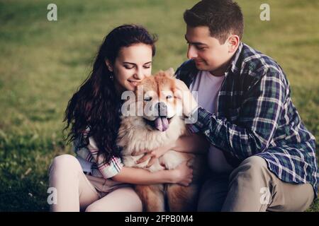 Paar spielen mit ihrem Hund im Sommerpark Stockfoto