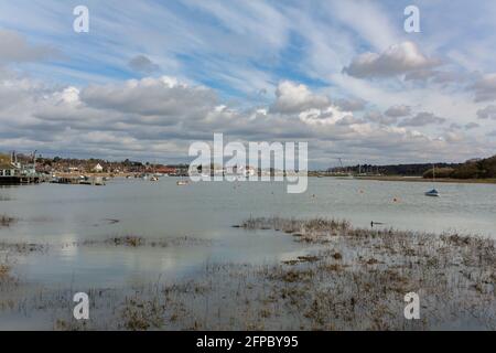 Blick den Fluss Deben hinunter zur Gezeitenmühle hinein Woodbridge bei Flut mit einer Vielzahl von Booten vor Anker Im Fluss an einem Frühlingstag Stockfoto