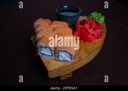 Rollt Philadelphia mit Sauce und Wasabi auf einem Holzständer. Stockfoto