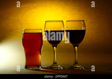 Zwei Weingläser gefüllt mit Rotwein und einem Pint Ein Glas Bier Stockfoto