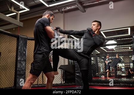 Mixed Martial Artists Training vor dem Kampf, üben Kickboxen, Kraft und Motivation. Sportler, die selbstbewusst trainieren, tragen Handschuhe Stockfoto