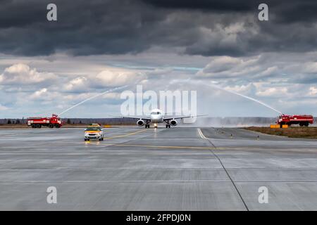 Wassergruß mit Feuerwehrauto am Flughafen zuerst Besuchen Sie das Passagierflugzeug Stockfoto