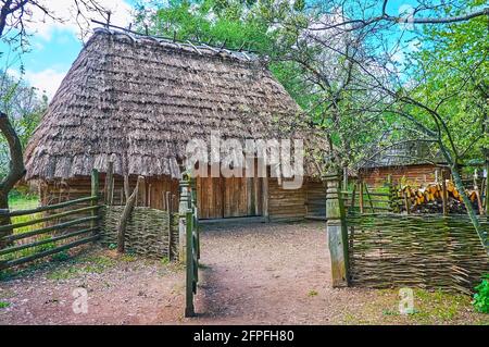 Das geöffnete Wicket vor der alten Holzscheune mit Reetdach, dem Schmiedehandgut im Kosakendorf Mamajeva Sloboda Scansen, Kiew, Ukraine Stockfoto