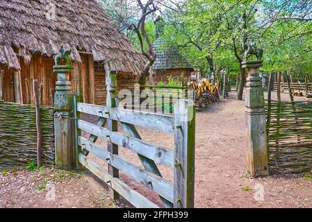 Das Tor des alten Schmiedehauses, geschmückt mit kleinen Reiterskulpturen, Mamajeva Sloboda Kosakendorf, Kiew, Ukraine Stockfoto