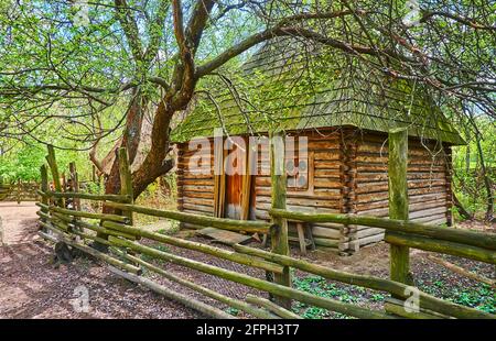 Das alte Holzhaus hinter dem Holzzaun im Kosakendorf Mamajeva Sloboda, Kiew, Ukraine Stockfoto