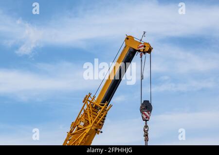 Kran mit Teleskoparm am bewölkten Himmel Stockfoto