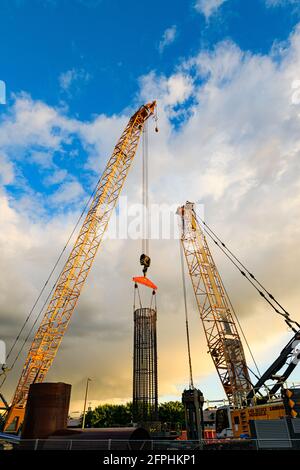 Redmond, WA, USA - 19. Mai 2021; Bau von Kranen auf einer neuen Baustelle in der Innenstadt von Redmond Washington vor stürmischem Himmel Stockfoto