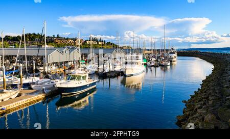 Edmonds, WA, USA - 20. Mai 2021; Hafen von Edmonds an einem ruhigen Abend in Washington, fernem Sturm im Süden, Vergnügungsboote hinter dem Wellenbrecher Stockfoto