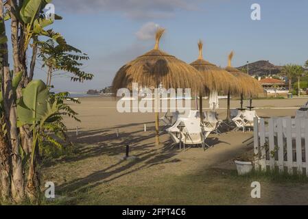 Landschaft eines Strandes mit Klappstühlen und Sonnenschirmen in Malaga, Spanien Stockfoto