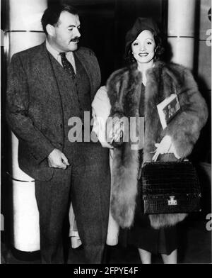 1937 , USA : der Filmstar MARLENE DIETRICH ( 1901 - 1992 ) , zur Zeit des FILMENGELS ( Angelo ) von Ernst Lubitsch , mit dem amerikanischen gefeierten Schriftsteller ERNEST HEMINGWAY ( 1899 - 1961 ). Dietrich hält eine Kopie eines Hemingway-Buches ' zu haben und nicht haben '( Avere e non avere ) von pubblisher Scribner's . Dieses Buch wurde 1944 (ACQUE DEL Sud) mit Humphrey Bogart und Lauren Bacall für den Film adaptiert. Der von Howard Hawks inszenierte Film veränderte den Schauplatz der Geschichte von Key West zu Martinique.das Drehbuch, das den Roman mit großer Freiheit neu interpretiert, wurde von Jules Furthman und Nobel la gebaut Stockfoto