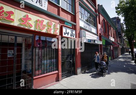 Vancouver, Kanada. Mai 2021. Am 20. Mai gehen Menschen an geschlossenen Geschäften entlang einer Straße in Chinatown, Vancouver, British Columbia, Kanada, vorbei. 2021. Nachdem die COVID-19-Pandemie seit über einem Jahr leidet, rufen Unternehmen in Chinatown, einer der Touristenattraktionen in Vancouver, um Hilfe bei der Rückkehr von Besuchern. Quelle: Liang Sen/Xinhua/Alamy Live News Stockfoto