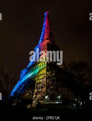 Paris, Frankreich - 3. Februar 2017: Vertikaler Blick auf den Eiffelturm, während er nachts in Regenbogenfarben leuchtet. Zum Teilen Stockfoto