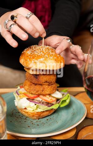 Der Bio Beef Burger mit Zwiebelringen und frisch geschnittenen Pommes frites. Whistler, BC, Kanada. Stockfoto