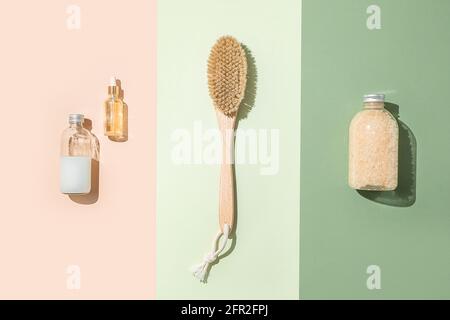 Körperbehandlung und Spa-Zusammensetzung. Flaches Lay mit natürlichen Schönheitsprodukten. Badesalz, Serumflasche. Bürste für trockene Anti-Cellulite-Massage. Dropper Stockfoto