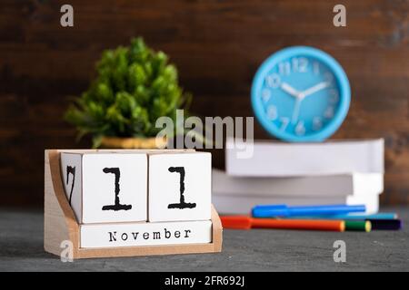 November. November 11 Holzwürfelkalender mit unscharfen Objekten auf dem Hintergrund. Stockfoto