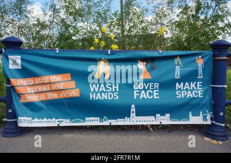 Waschen Sie sich die Hände, decken Sie das Gesicht ab, und lassen Sie das COVID 19-Banner am Straßenrand abzeichen Stockfoto