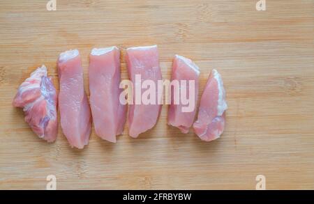 Nahaufnahme gesundes Fleisch Schweinsfilet, das in dicke Stücke geschnitten wurde, frisches Schweinefleisch auf Holzschneidebrett, schön geschnittene ​​pork anordnen, top vie Stockfoto