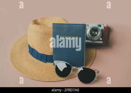 Reisebedarf: Reisepass, Sonnenbrille, Hipster Hut, Vintage-Kamera. Urlaubsobjekte auf rosa Hintergrund Stockfoto