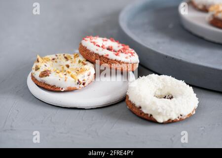 keto-Donuts mit Glasur und Streuseln sublimierter Erdbeere. Ketogenes kohlenhydratarmeres Gericht. Zuckerfreie Donuts mit verschiedenen Zuckungen. Nahaufnahme Stockfoto