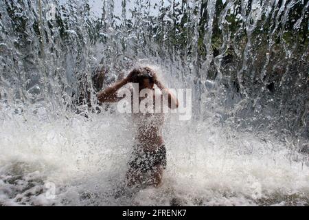 Weißrussland. Minsk - 11.06.2010: Im heißen Sommer badet das Kind im Stadtbrunnen. Stockfoto