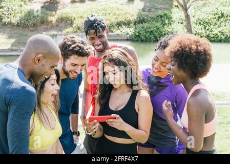 Eine Gruppe von Läufern, die sich auf einem Handy etwas sehr Lustiges angeschaut haben. Stockfoto