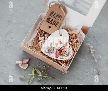 Natürliches Florentina Aroma handgemachtes Wachssachet mit getrockneten Blumen verziert. Öko-Verpackung mit Papierfüllung. Parfümiertes Herz für Garderobe Frische. Stockfoto