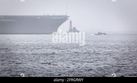 Ein US Navy Aircraft Carrier wird aus dem Hafen von Yokosuka in den Nebel der Tokyo Bay in Japan begleitet. Stockfoto