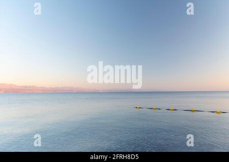 Sonnenuntergang über dem Roten Meer mit rosa orangenen Bergen im Hintergrund. Eilat, Aqaba, Israel, Jordanien . Hochwertige Fotos Stockfoto