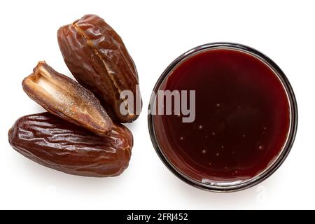 Datieren Sie Sirup in einer Glasschale neben ganz und schneiden Sie trockene entkernte Datteln isoliert auf weiß. Draufsicht. Stockfoto