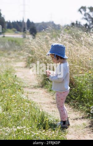 Junge Kleinkind Mädchen spielen im Freien, allein in der Natur Stockfoto