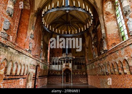 Mittelalterlicher Saal in einem antiken Schloss und Blick auf den großen Kerzenleuchter an der Decke, Malbork, Polen Stockfoto