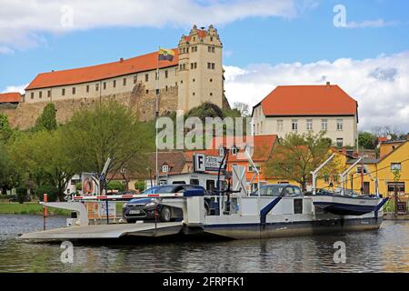 Wettin, Deutschland. Mai 2021. Die Fähre 'Wettin' überquert die Saale. Im Hintergrund thront das Schloss Wettin auf einem Felsen. Wettin ist die Stammburg der Wettins, der Markgrafen, Kurfürsten und Könige von Sachsen. Idyllisch im Naturpark Niedersaaltal gelegen, ist die Stadt ein beliebtes Ausflugsziel in der Region. Quelle: Peter Gercke/dpa-Zentralbild/ZB/dpa/Alamy Live News Stockfoto