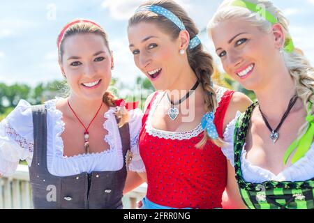 Freunden, die zusammen bayerische Messe in Tracht oder Dirndl Stockfoto