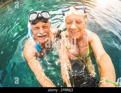 Glückliches Rentnerpaar, das Selfie auf einem tropischen Meeresausflug gemacht hat Wasserkamera und Schnorchelmasken - Bootsfahrt zum Schnorcheln Exotische Szenarien Stockfoto