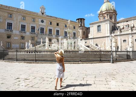 Reisen in Sizilien. Rückansicht einer jungen schönen Frau, die in der Nähe des monumentalen Praetorianerbrunnens in Palermo, Italien, geht. Stockfoto