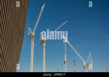 Krane arbeiten an einem neuen Gebäude auf dem Gelände der Olympischen Spiele 2012 in London, Stratford. Stockfoto