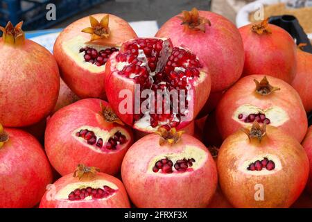 Granatapfel wird auf dem lokalen Markt verkauft. Rote Früchte im Schnitt liegen auf der Theke. Nützliche Früchte mit vielen Vitaminen und Mikroelementen. Stockfoto