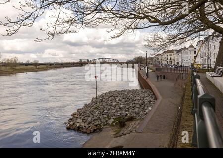 ZUTPHEN, NIEDERLANDE - 20. Apr 2021: Aussichtspunkt in Zutphen, Niederlande, über den Fluss IJssel, vorbei an historischer mittelalterlicher Stadt mit Zweigen Stockfoto