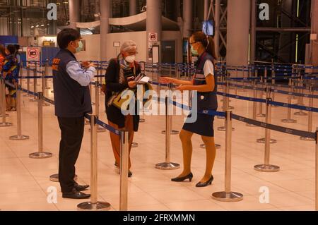 Eine ältere Frau, die eine schützende Gesichtsmaske/Abdeckung trägt, durchläuft während der Coronavirus-Epidemie eine Einwanderungskontrolle an einem leeren internationalen Flughafen von Suvarnabhumi. 27. Februar 2020. Bangkok, Thailand. © Kraig Lieb Stockfoto